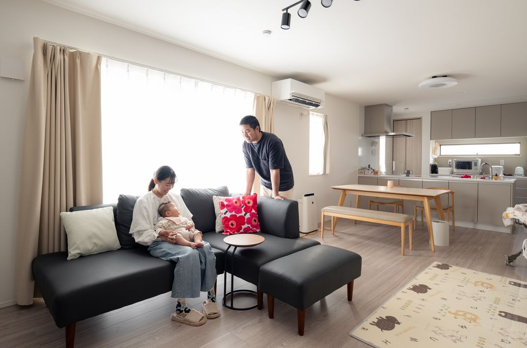 プリンシパルホームで家を建てたご家族。リビングでくつろぐご夫婦と赤ちゃん