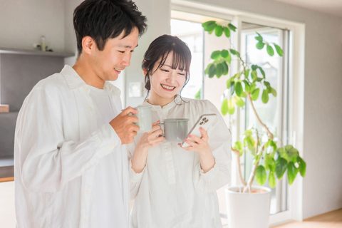 スマートフォンで見学会を予約する夫婦